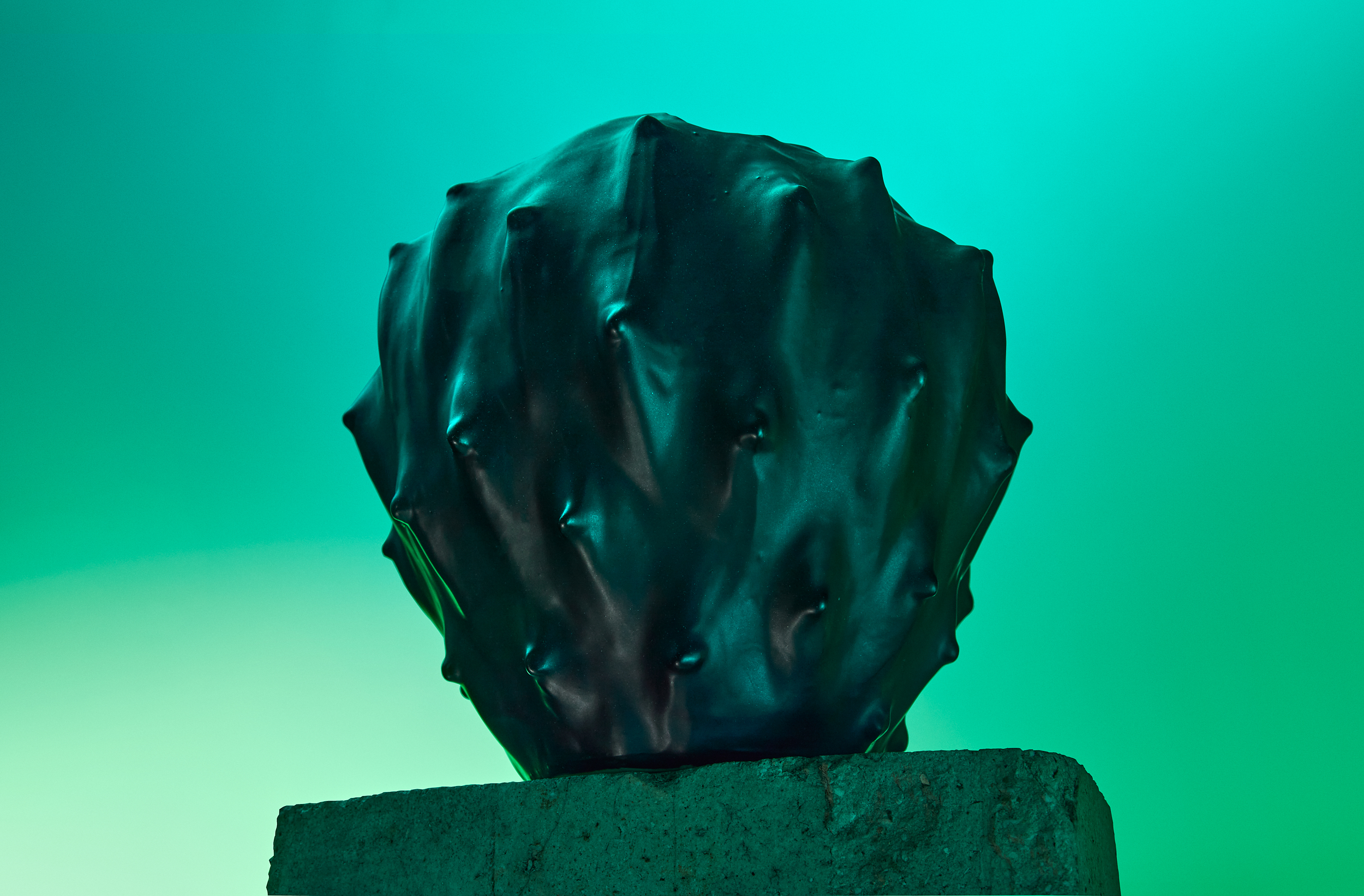 Hourglass and stone cylinders combined on a pedestal in green studio light